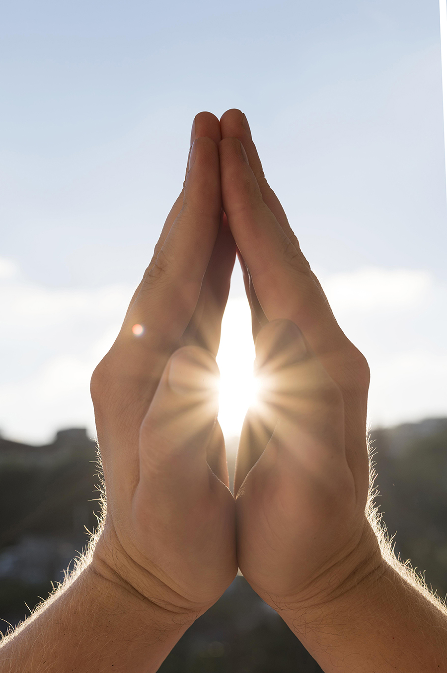 LaHoChi, deux mains en forme de namasté laissant passé les rayons du soleil a l'intérieur, offrant un sentiment de paix et d'apaisement