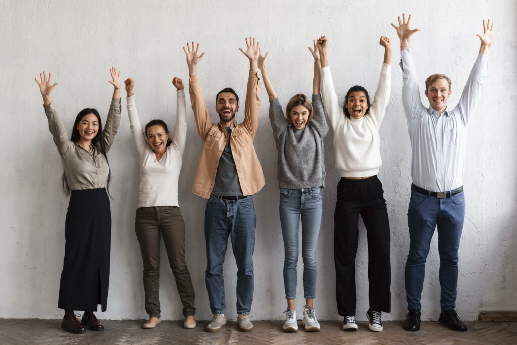 Sophrologie, un groupe de personne avec les bras levé et un sourire sur le visage marquant les bienfaits de la sophrologie apportant une meilleure confiance en soi et estime soi