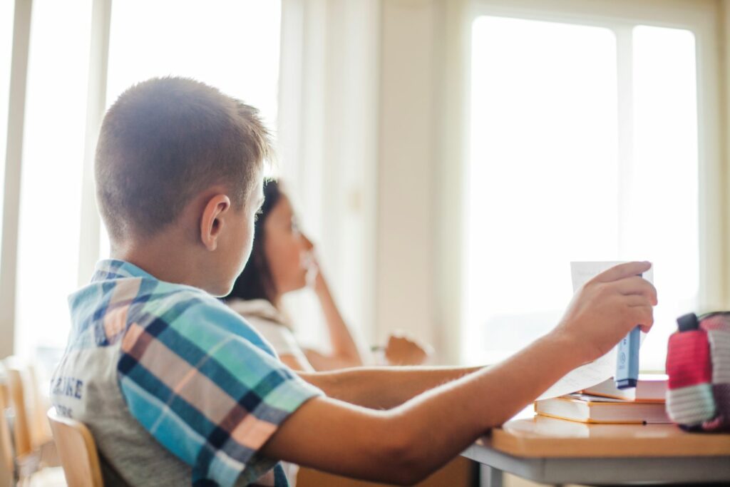 enfant en classe rêvassant et regardant par la fenêtre