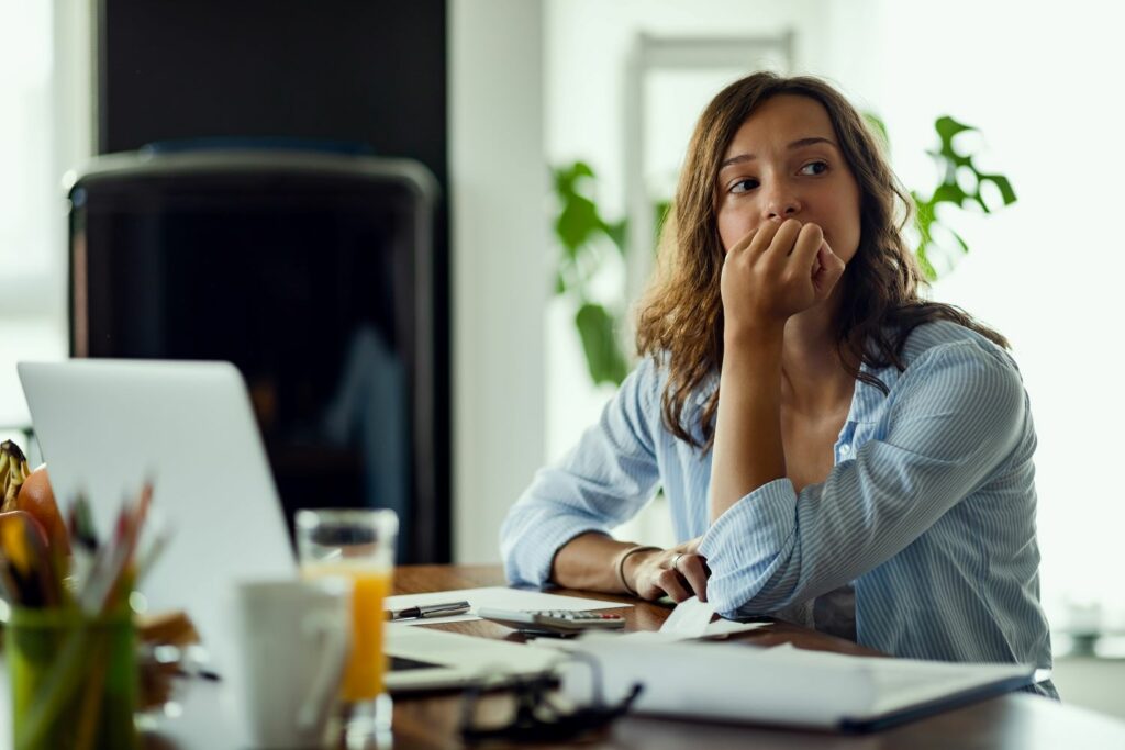 Une jeune femme inquiète réfléchit à quelque chose, on y observe sur son visage du stress.