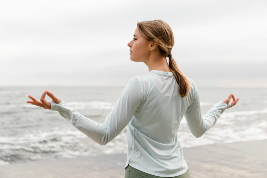 femme meditant en bord de mer inspirant l equilibre