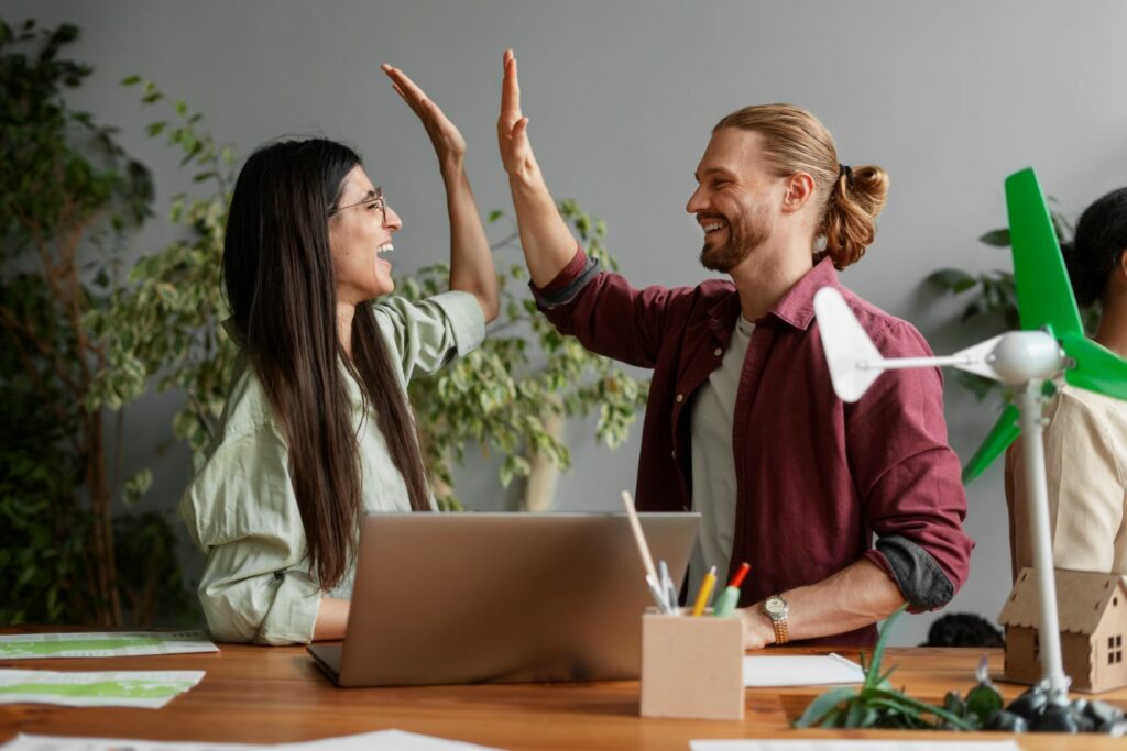 2 personnes sur le lieu de travail se tapent dans la main montrant leur bien être