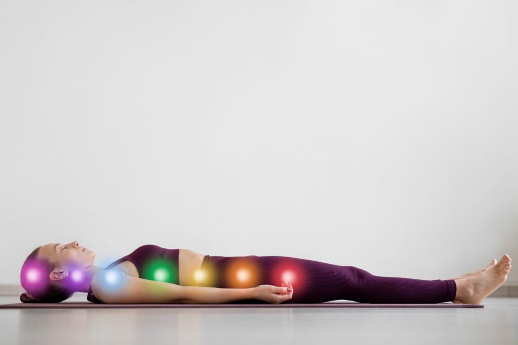 femme allongée sur un tapis de yoga et aligner avec ses chakras