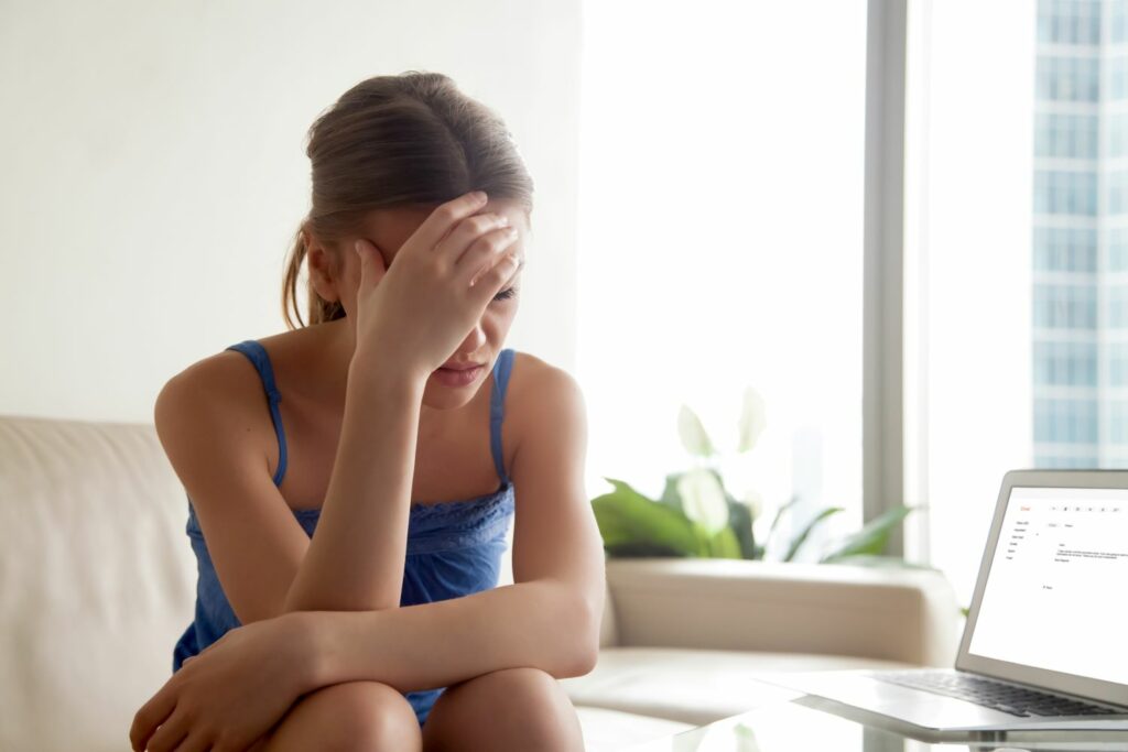 jeune femme qui se tient la tête assimilé a trop de stress