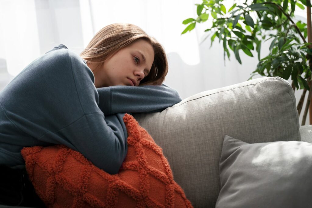 jeune femme triste sur un canapé dans ses pensées