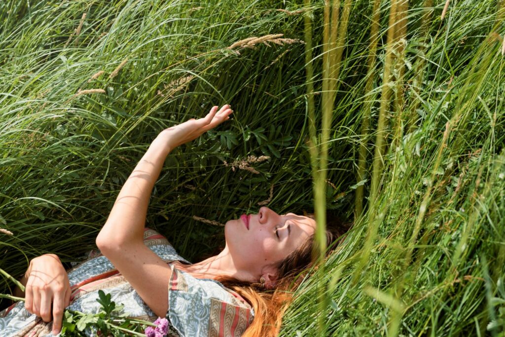 femme allongé dans les hautes herbes sentiments de bien être et d'instant présent