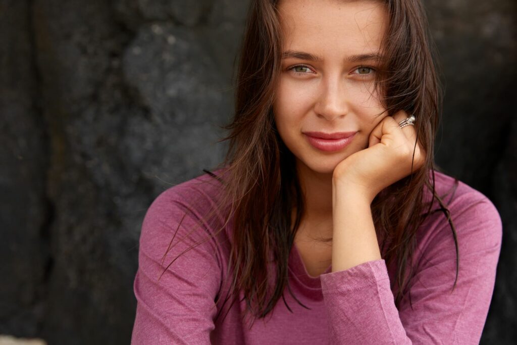 jeune femme souriante écoutant ses intuitions aligné avec elle même sortant de ses mécanismes de protection