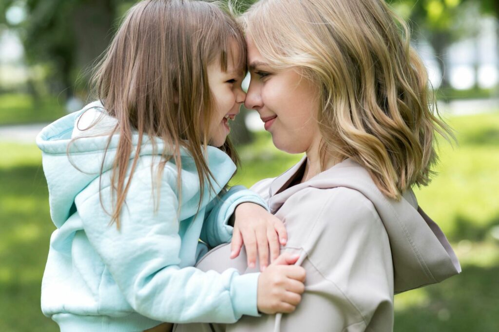 une mère et sa fille front contre front souriantes montrant leur complicité