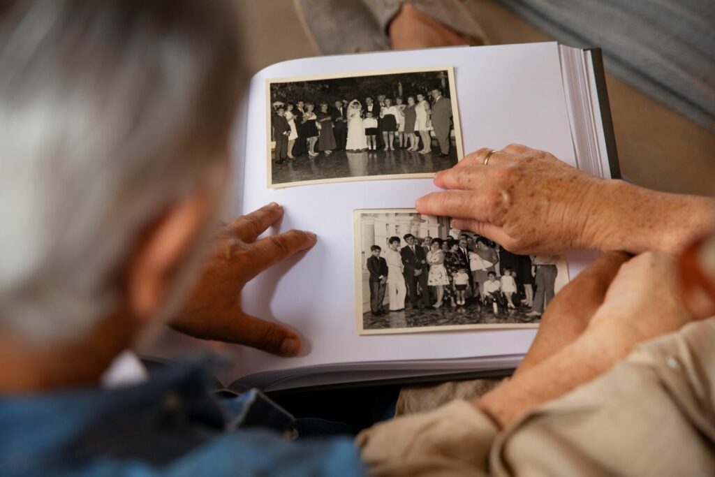 deux personnes âgées feuilletant un album photo faisant référence à l'héritage transgénérationnel