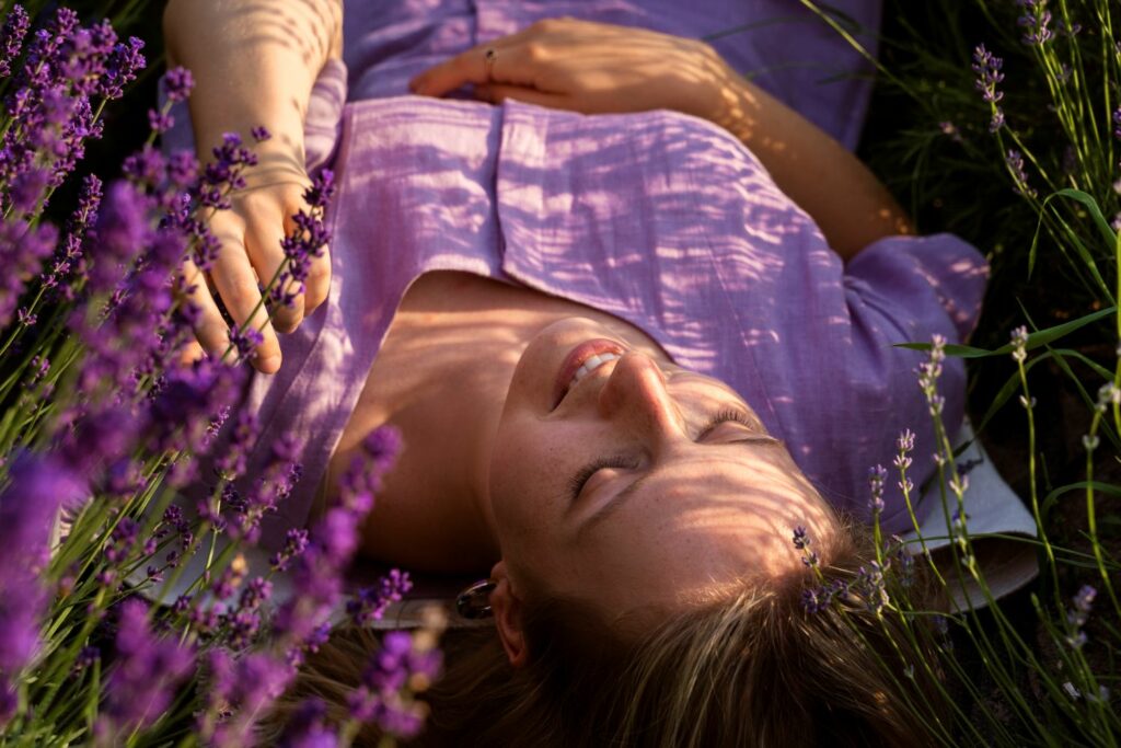 femme allongée dans un champ de lavande inspirant le bien être grâce a la reprogrammation de ses croyances