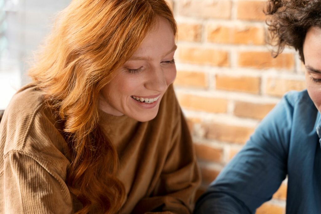 2 femmes assise et qui rigole marquant une communication harmonieuse